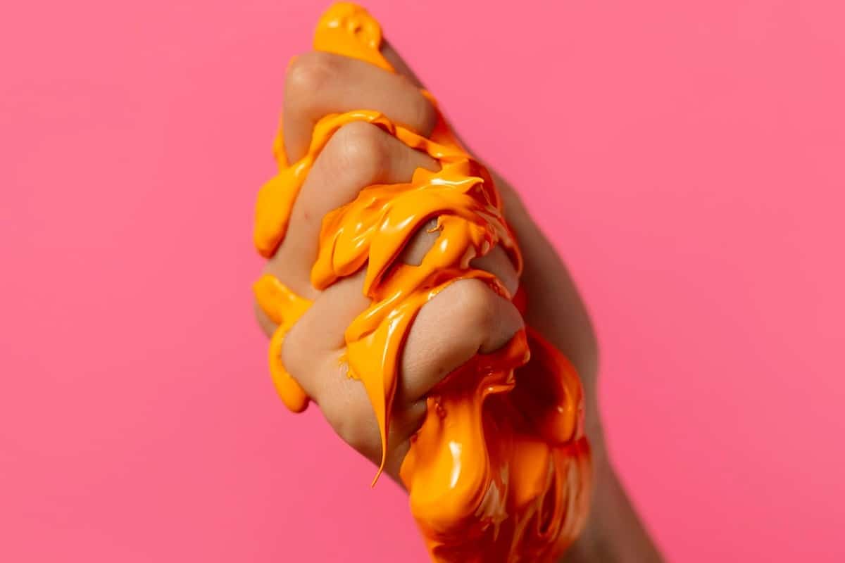 main qui broie du slime orange